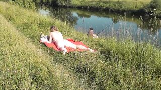 Nudist beach. Public nudity. Sexy MILF without panties and bra sunbathes naked is not shy about fisherman. Naked in public. Milf - 10 image
